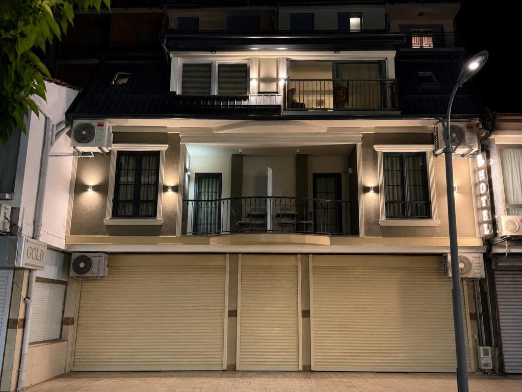 a house with two garage doors and a street light at Gold City Hotel by Erebara in Debar