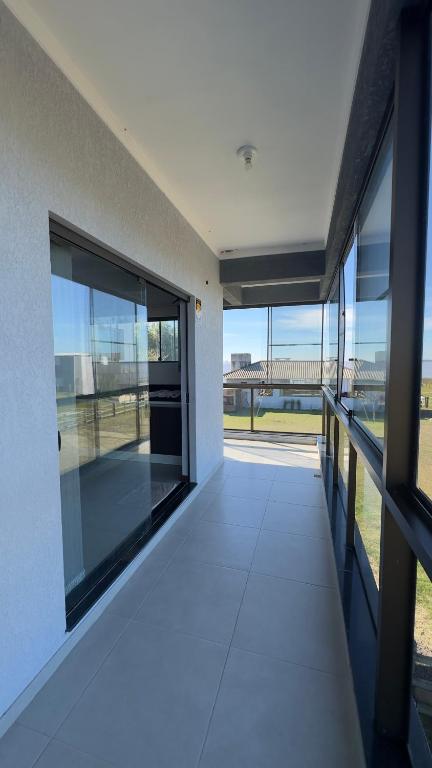 an empty building with large windows and a view of the ocean at Kitnet beira da lagoa in Terra de Areia