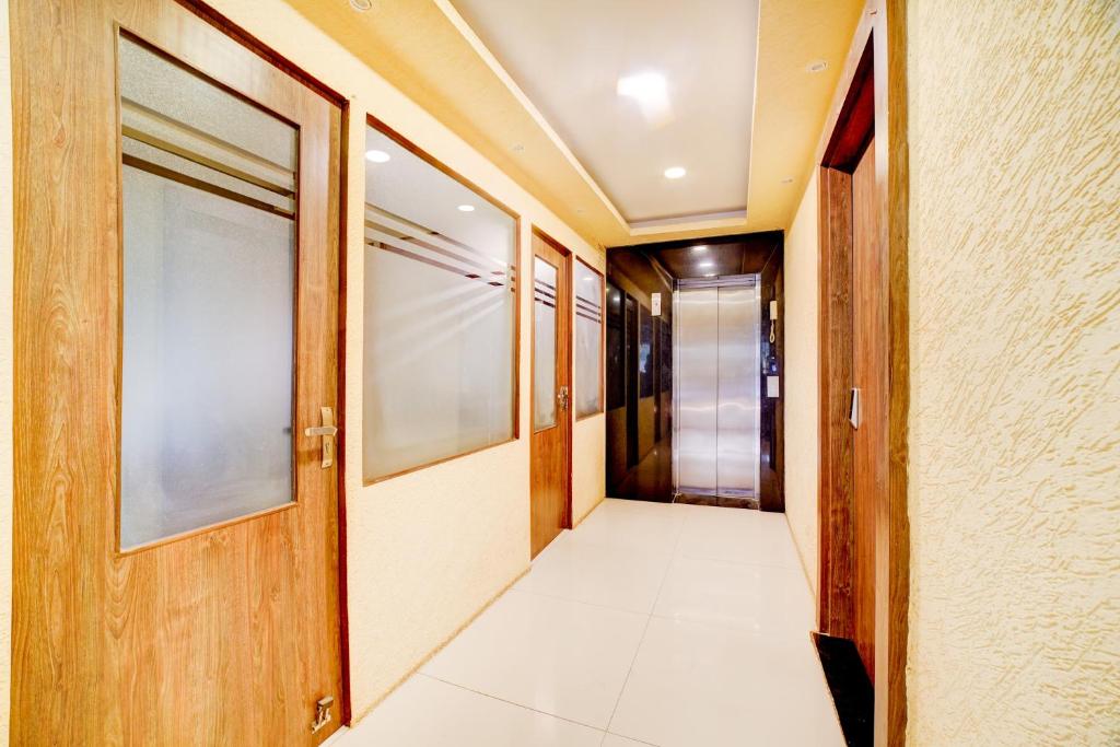 a corridor of a hallway with a door and a tile floor at Hotel O Ganpati in Bhopal