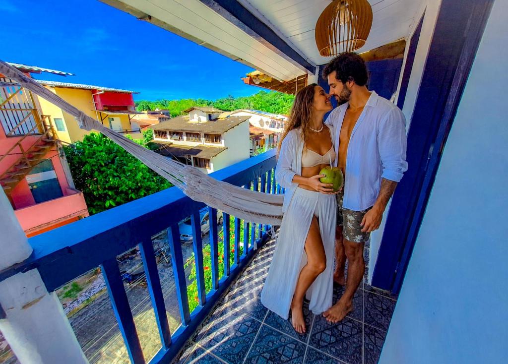 a couple kissing on the balcony of a house at Pousada Mar de Itacaré in Itacaré