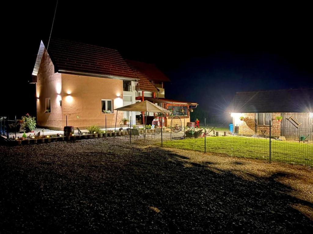 a house at night with a fence in front of it at Kuća za odmor-Zeleni raj in Srpska Kapela
