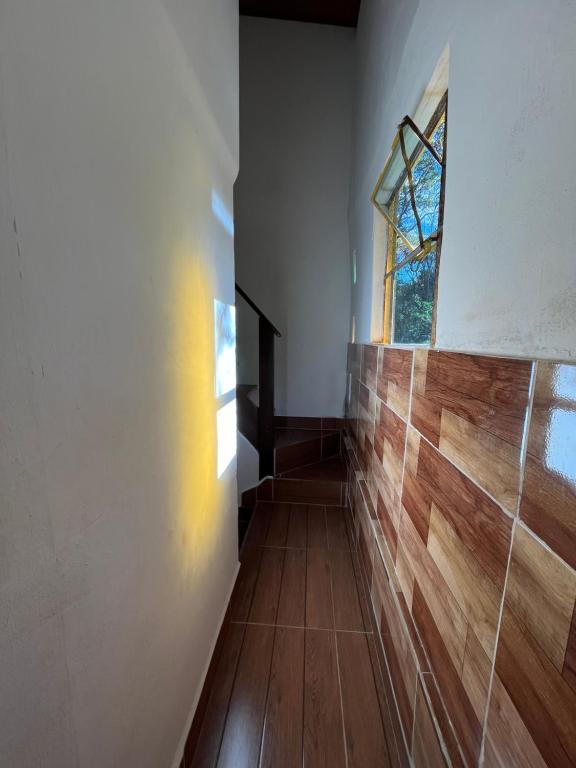 a hallway with wooden floors and a window at Casa de Marina in Palmeiras