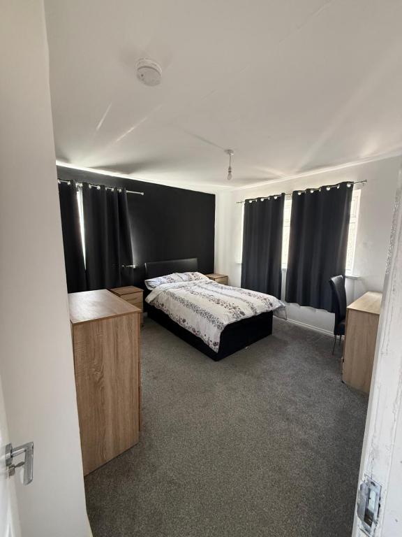 a bedroom with a bed and black curtains at 10 wyeverne road in Cardiff