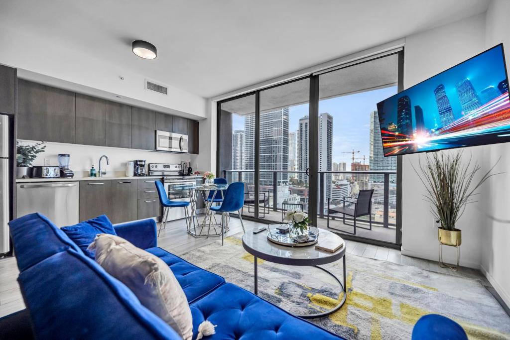 a living room with a blue couch and a kitchen at The Sanctuary King studio in Miami
