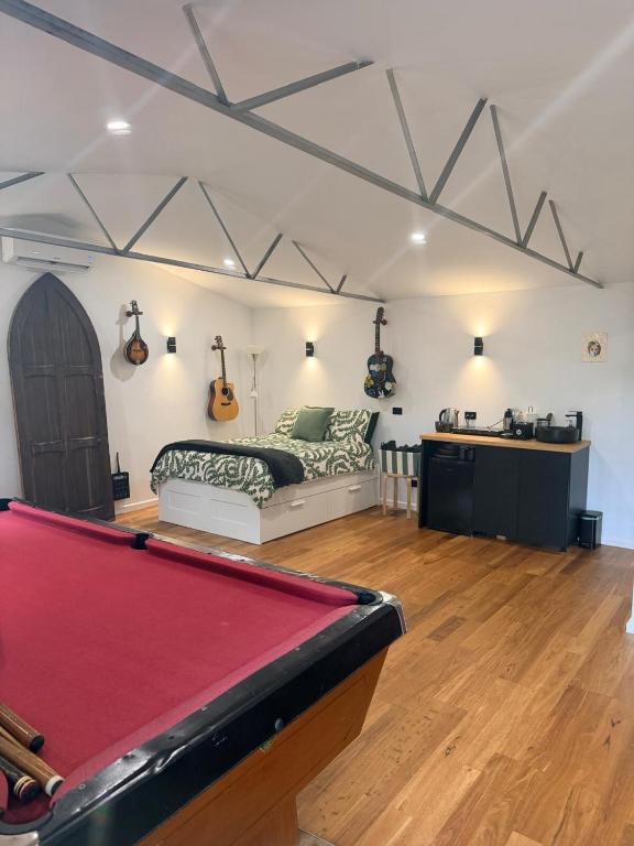 a room with a pool table and a bed at Mustang Studios in Canberra