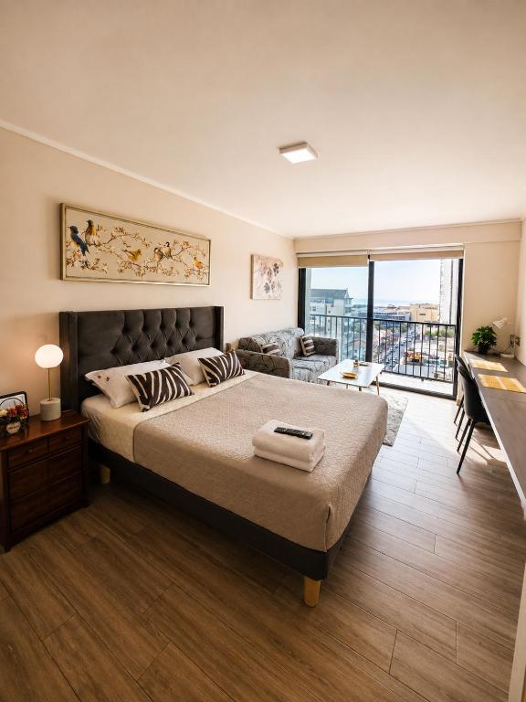 a bedroom with a large bed and a living room at Centro Vista Al Mar san Martin Coliving in Antofagasta
