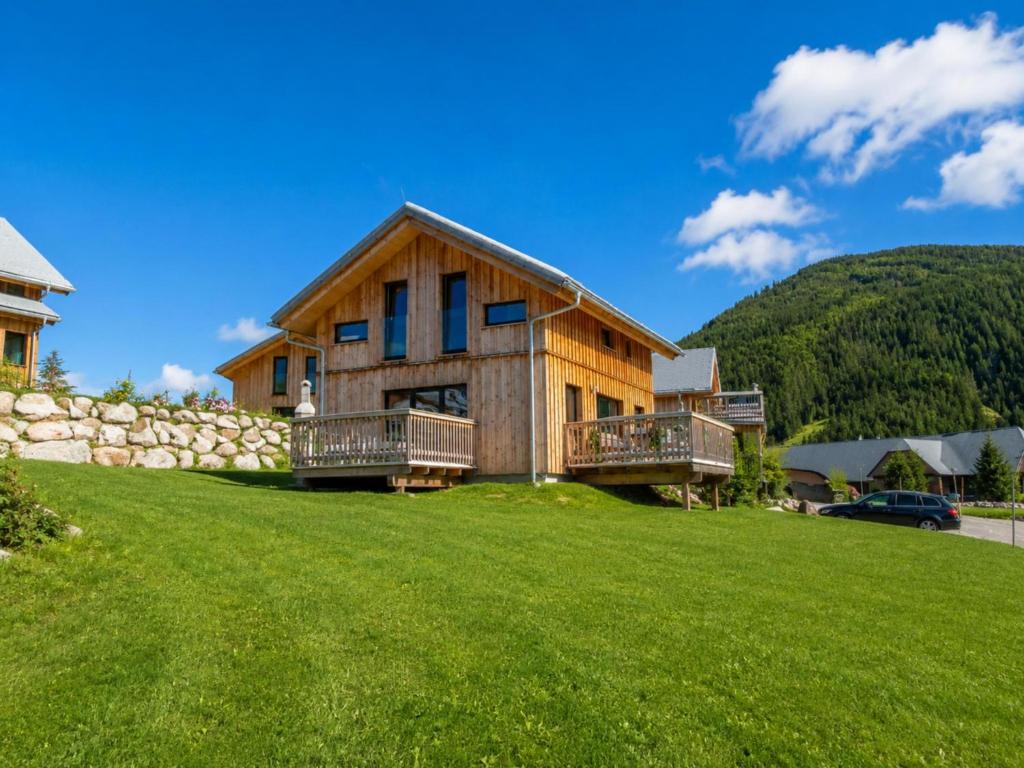 a log home with a grassy yard in front at Bärenschanze in Hohentauern
