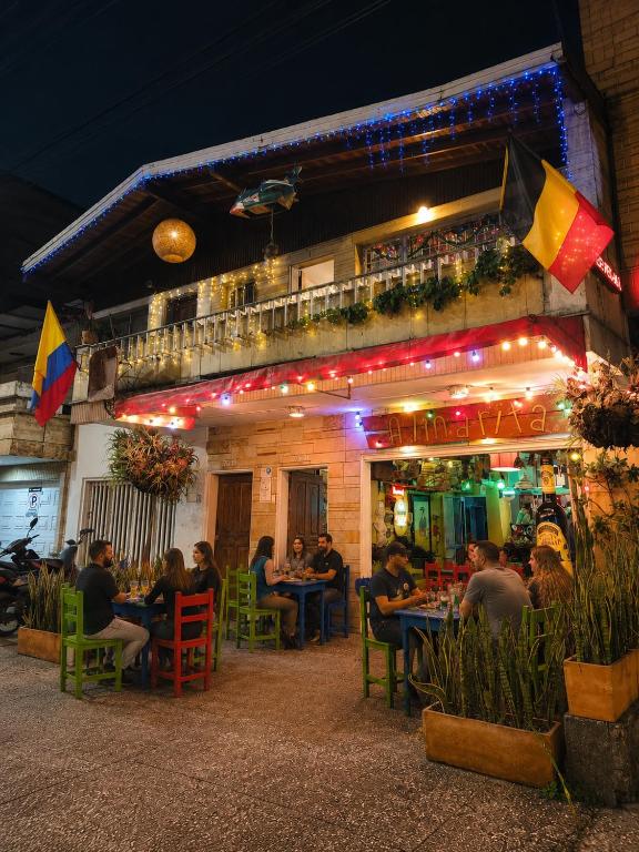 a group of people sitting at a restaurant at night at Casa Almarita Hostel Social Bar in Medellín