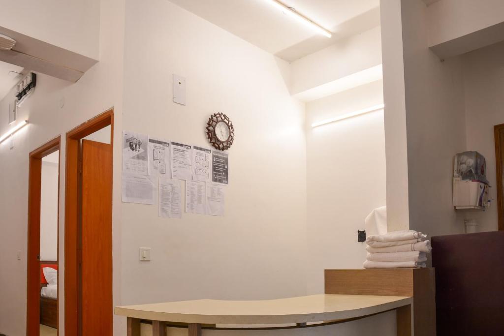 a room with a table and a clock on the wall at Super Collection O Sayhallo Kanchan in Bhubaneshwar