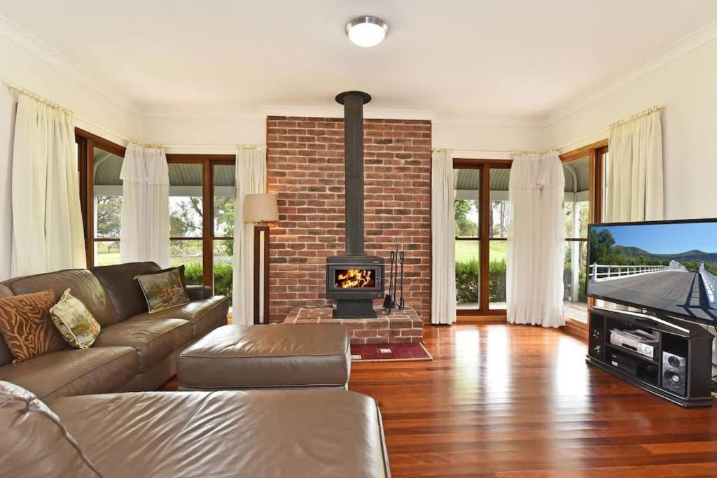 a living room with a couch and a fireplace at La Sila Homestead on Marrowbone in Mount View