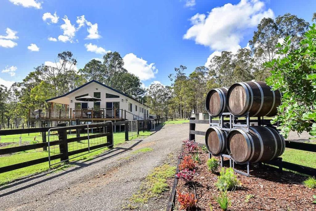 a group of barrels on a fence next to a house at Lamp Estate in Greta