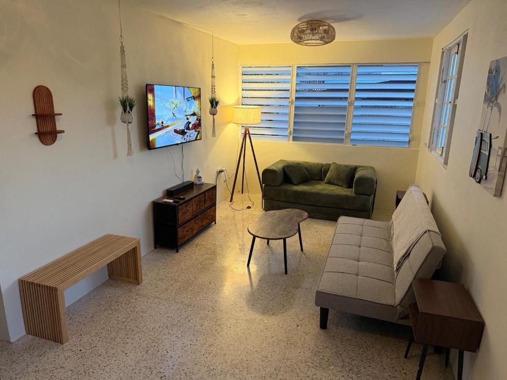 a living room with a green couch and a tv at Casa Brisa Beach House in Dorado