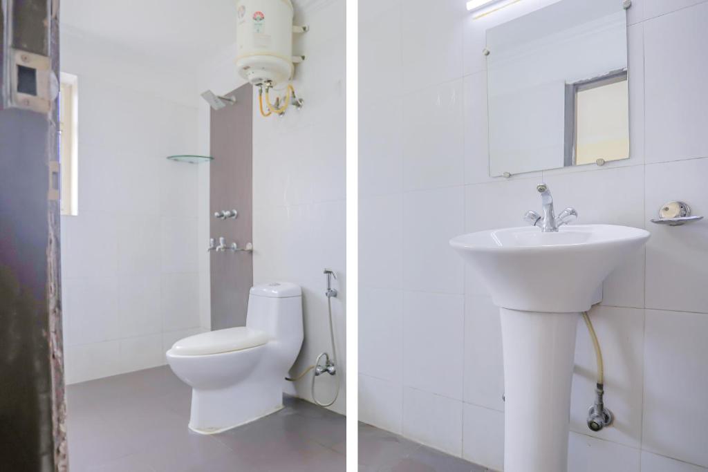 a white bathroom with a sink and a toilet at Collection O Green Park Residency 3 in New Delhi