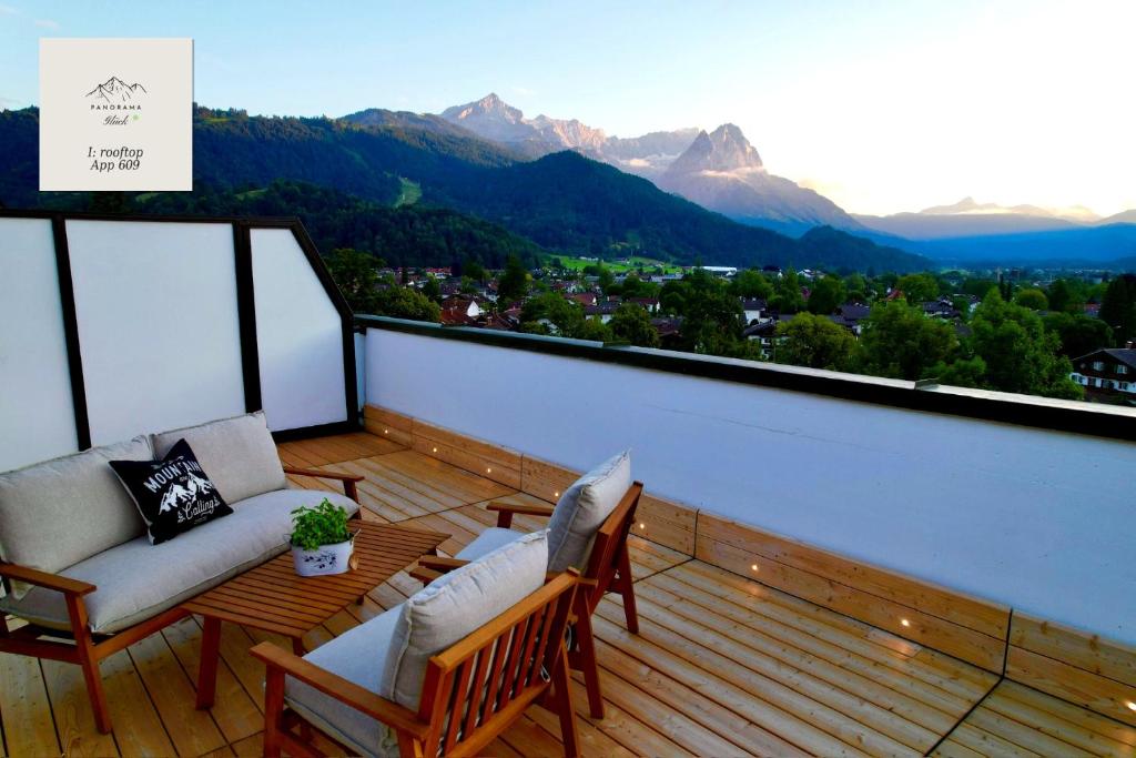 a balcony with two chairs and a table with a view of mountains at Panorama-Glück I & III in Garmisch-Partenkirchen