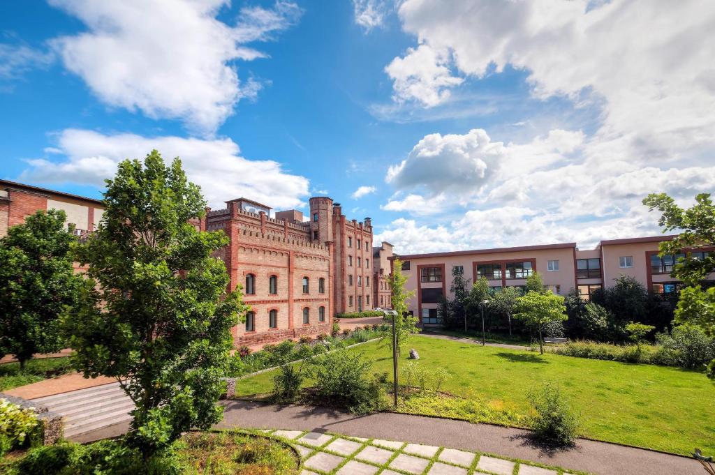a large brick building with a park in front of it at Comfort Aparthotel Mutzig Portes d'Alsace in Mutzig