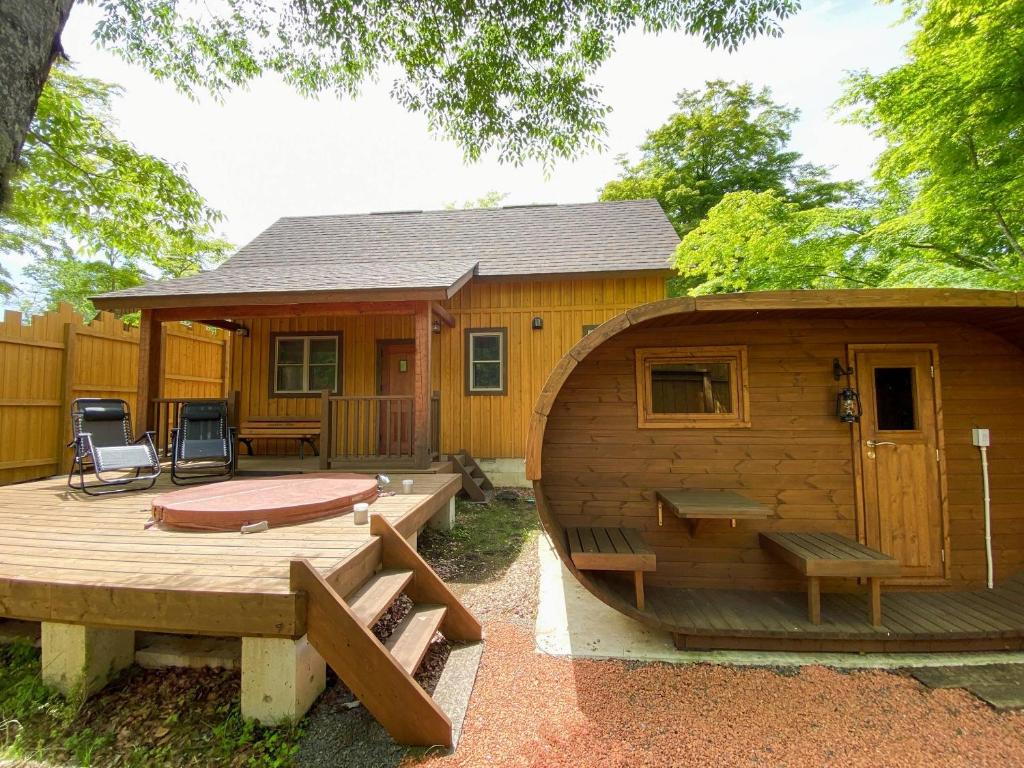 a large wooden cabin with a pool and a house at Resort Door in Yamanakako