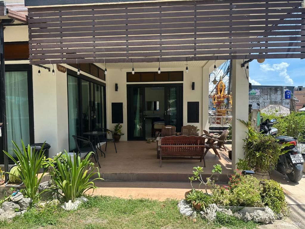 a house with a patio with a couch and a table at Wangta in Haad Rin