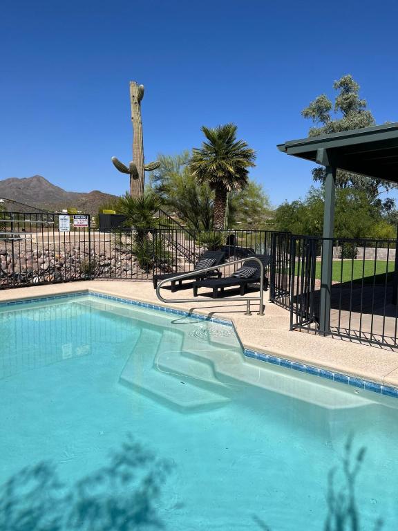 a swimming pool with two chairs next to a fence at The Tortolita House in Tucson