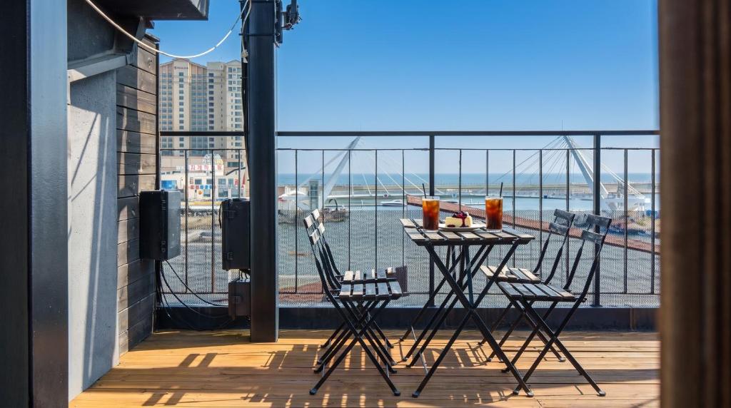a table on a balcony with a view of the water at Sokcho Maru Pension in Sokcho