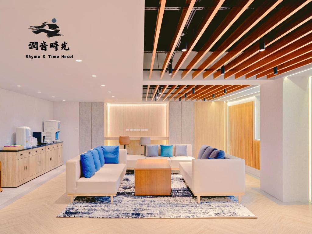 a waiting room with white chairs and blue pillows at Rhyme&Time Hotel in Kaohsiung