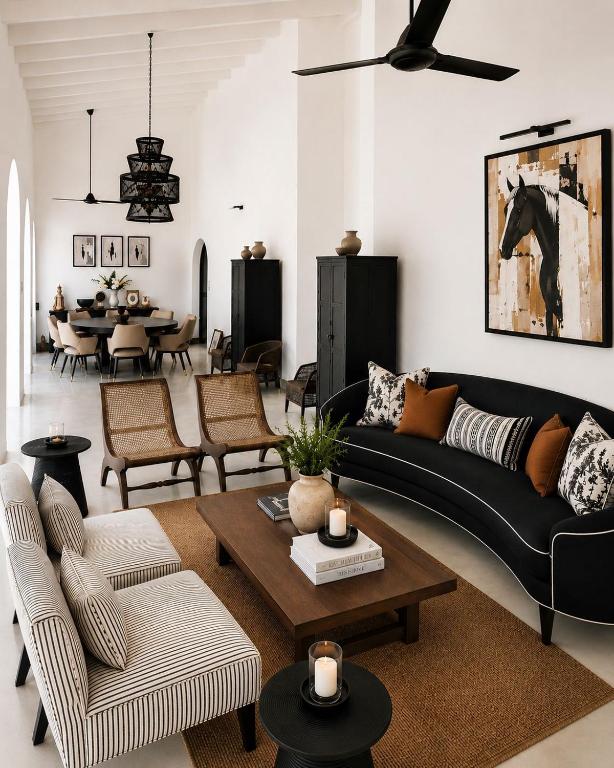 a living room with a black couch and a table at Casa Dega in Balapitiya