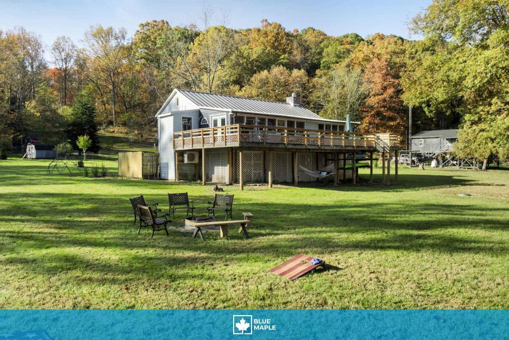 a large house with a deck on a field at Riverfront w Deck Grill Fire pit & Climbing Wall in Hedgesville