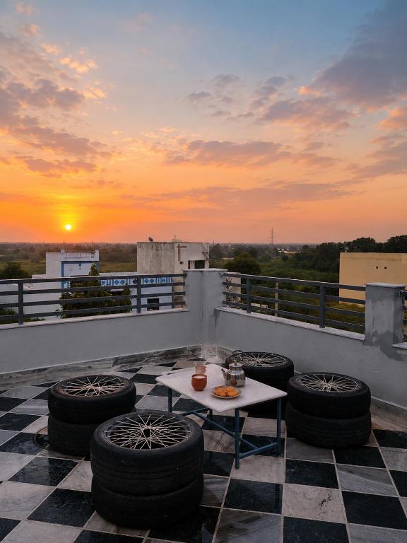 a rooftop patio with a table and some tires at Aeronest Villa "your new escape" in Udaipur