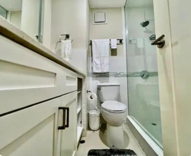 a white bathroom with a toilet and a shower at Royal Estate in Portmore