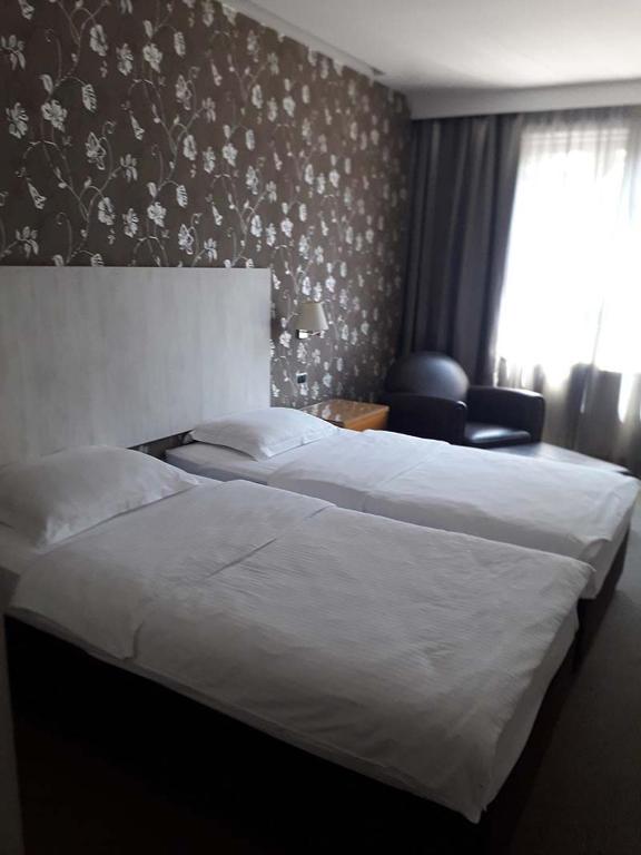 a hotel room with two beds and a window at Hotel 1000 Ruza in Belgrade