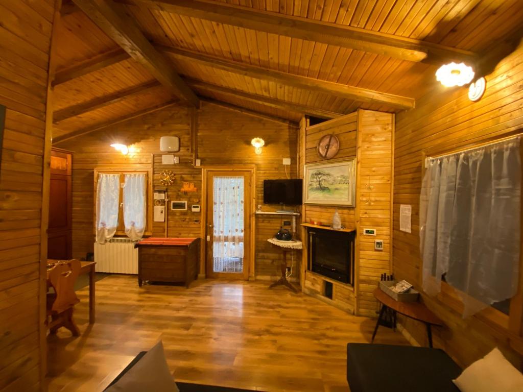 a living room with wooden walls and wooden floors at Casa vacanza Chalet Baita nel Bosco in LʼAquila