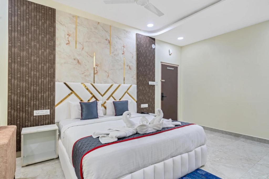 a bedroom with a large bed with towels on it at Hotel Skyland Khammam in Khammam