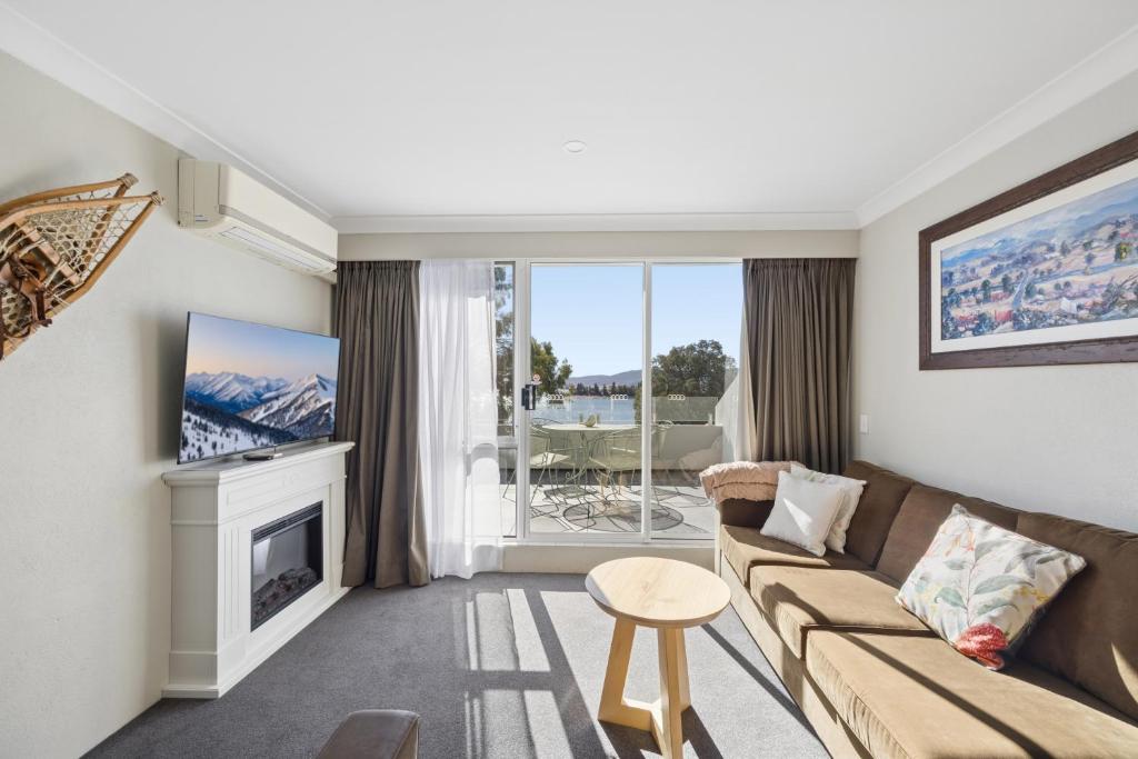 a living room with a couch and a fireplace at Horizons 404 in Jindabyne