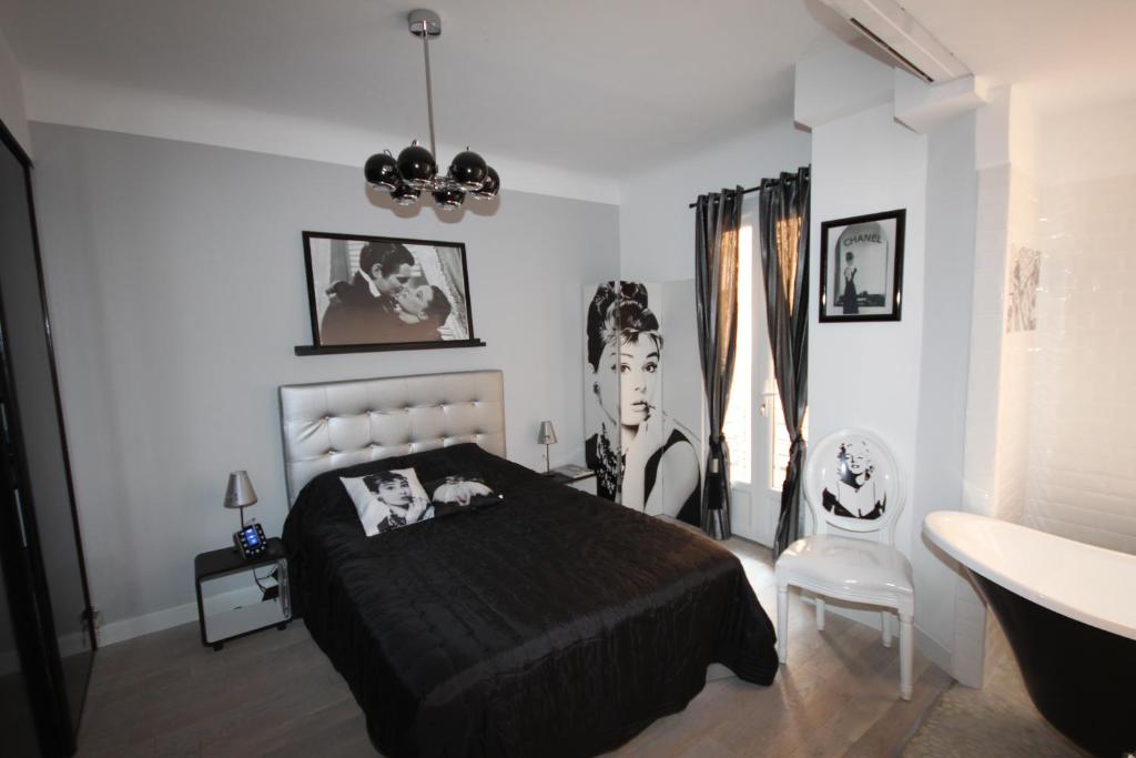 a black and white bedroom with a bed and a sink at From Hollywood to Bollywood 2 Bedrooms 2 Bathrooms - 1 min from Croisette&Beach, 12 Min from the Palais in Cannes