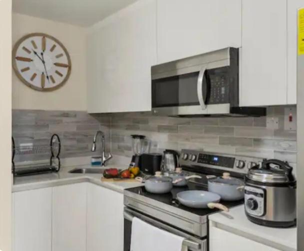 a kitchen with a stove and a clock on the wall at Deluxe suite in Portmore