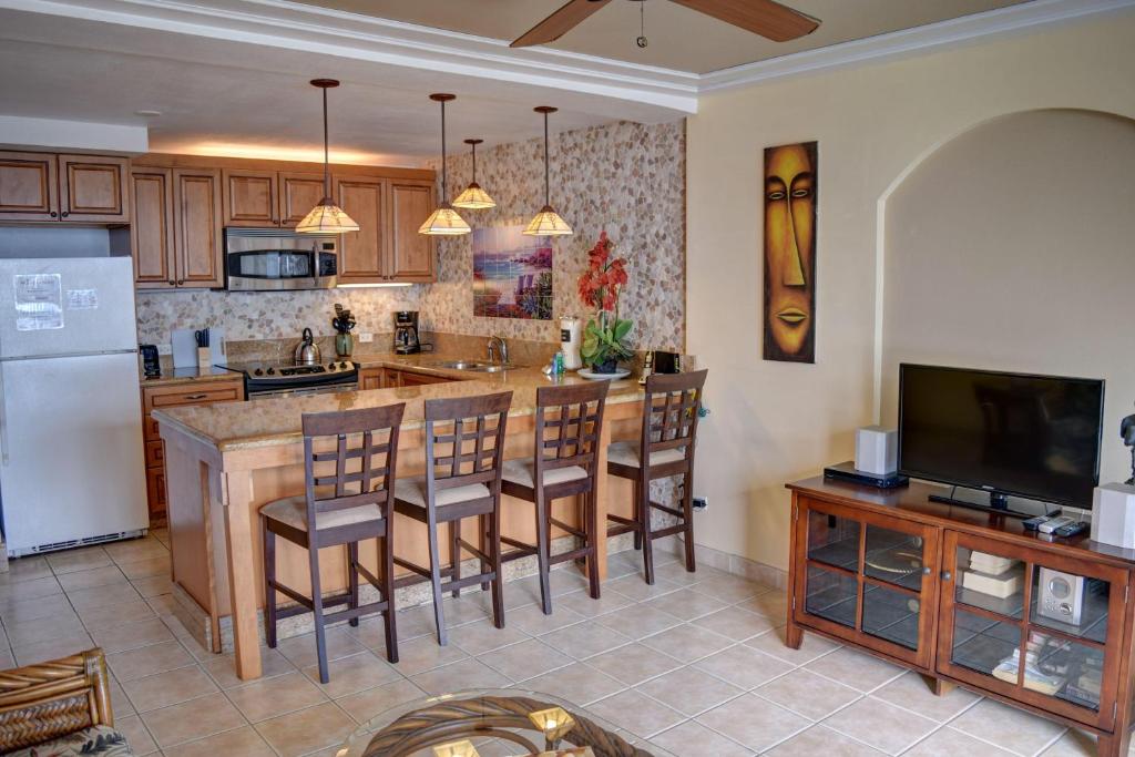 a kitchen with a island with chairs and a counter top at Hale Kai O'Kihei 302 in Kihei