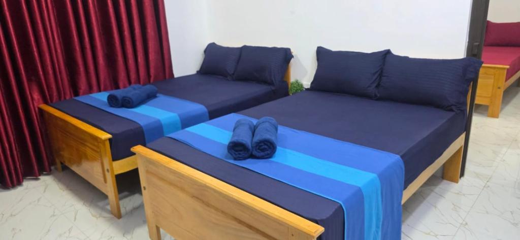 two beds with shoes sitting on them in a room at SK Guest House in Jaffna