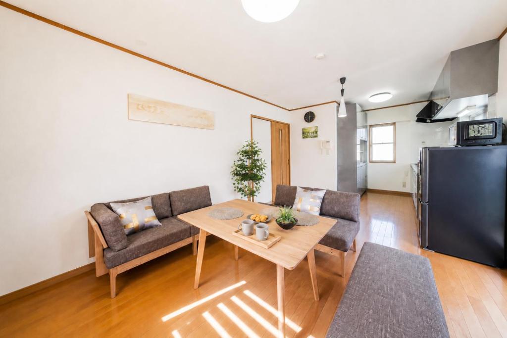 a living room with a table and chairs and a refrigerator at Villa Lotus in Kamakura