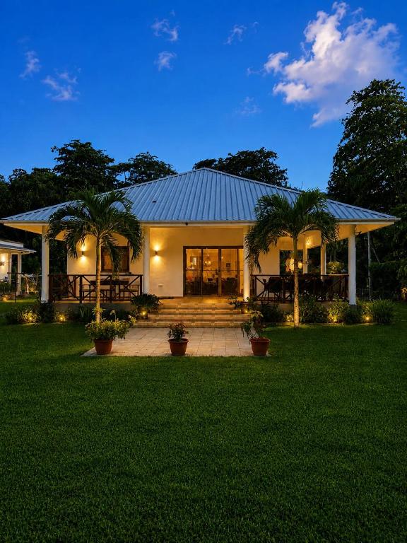 a house with palm trees in front of it at Villa Laure in Grand'Anse Praslin