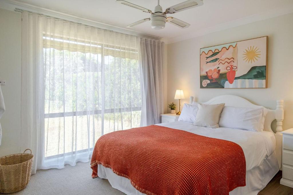 a bedroom with a bed and a large window at Narrawallee Nirvana in Narrawallee