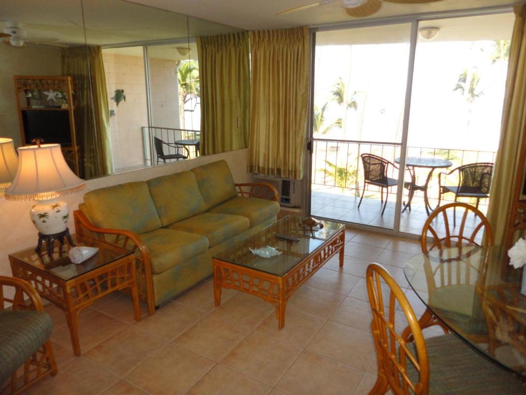 sala de estar con sofá, mesas y balcón en Hale Kai O'Kihei 317, en Kihei