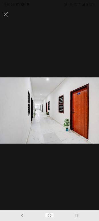 a hallway of a building with a wooden door at New Stay Hotel in Gurgaon