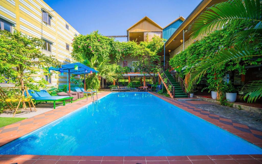a large blue swimming pool next to a building at Phong Nha Dawn Home in Phong Nha