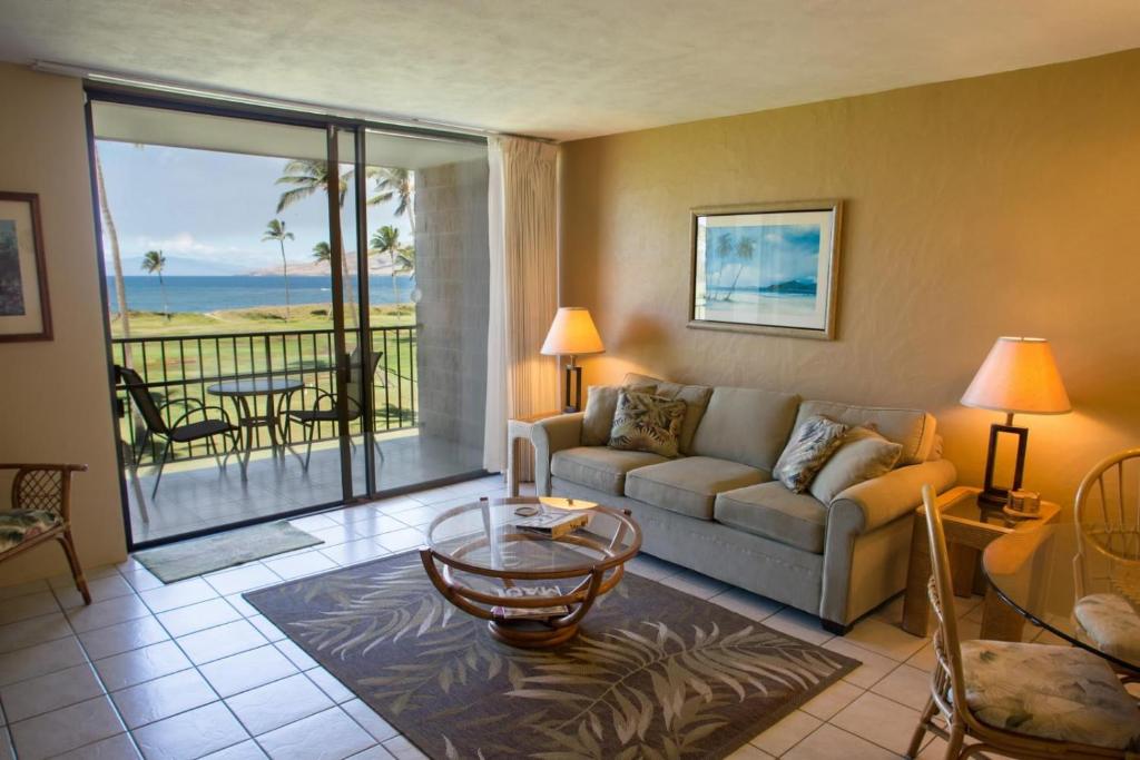 a living room with a couch and a view of the ocean at Kauhale Makai 335 in Kihei