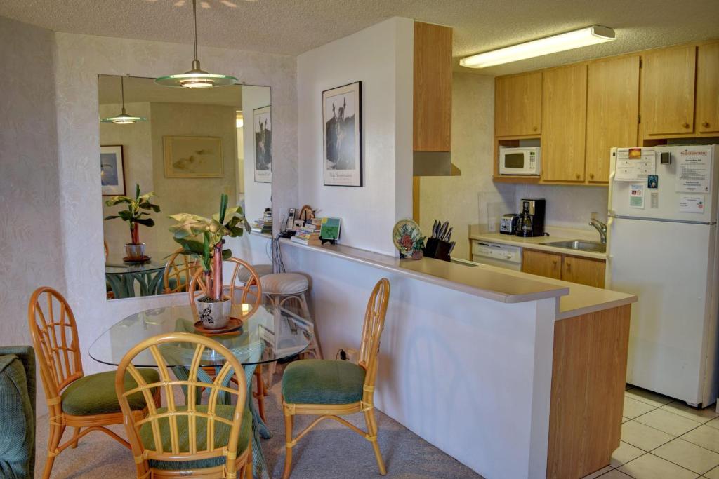a kitchen with a counter and a table and chairs at Kauhale Makai 230 in Kihei