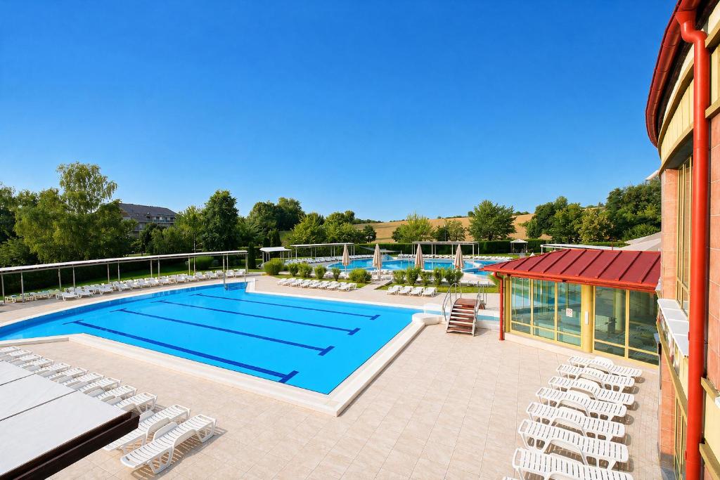 a swimming pool with lounge chairs and a swimming pool at Zalakaros Wellness Oázis Apt, nappali, 1háló, 4 fő in Zalakaros