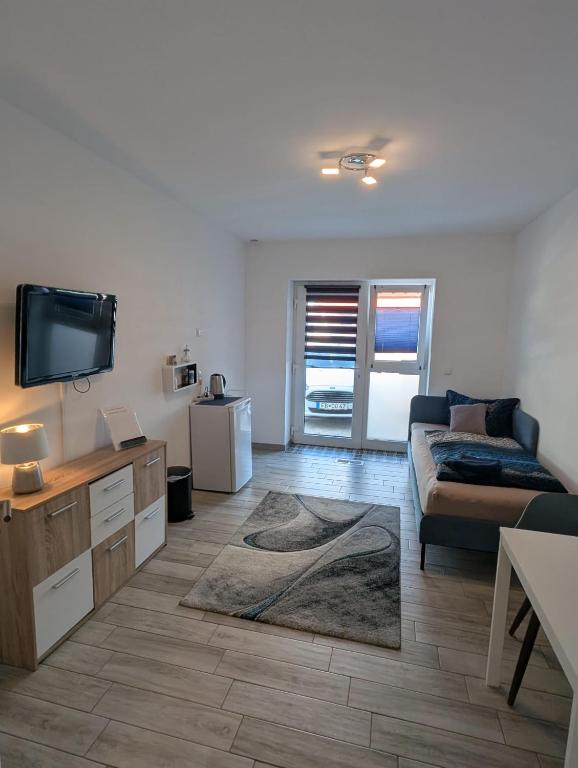 a living room with a couch and a flat screen tv at Nathalie in Bad Vilbel