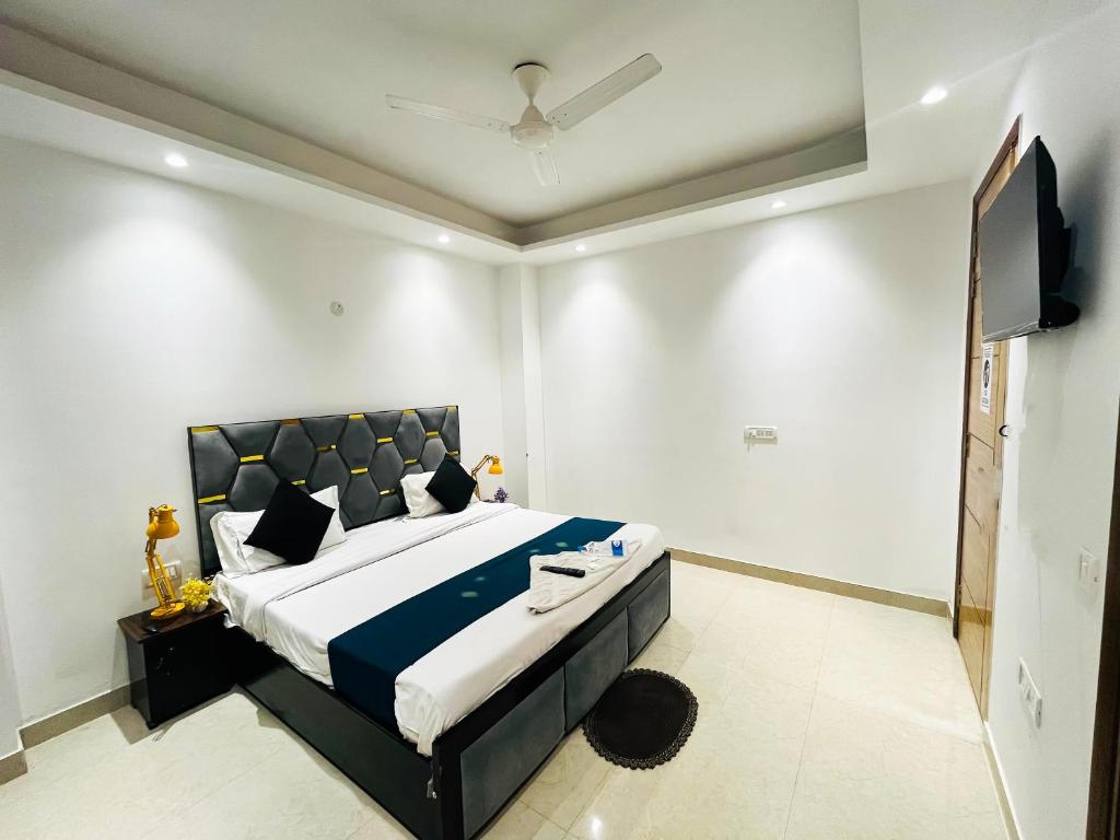 a bedroom with a large bed and a flat screen tv at Hotel fabulous - Malviya Nagar in New Delhi