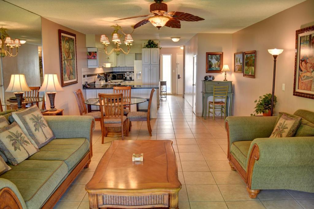 a living room with couches and a table and a kitchen at Kihei Akahi A104 in Wailea