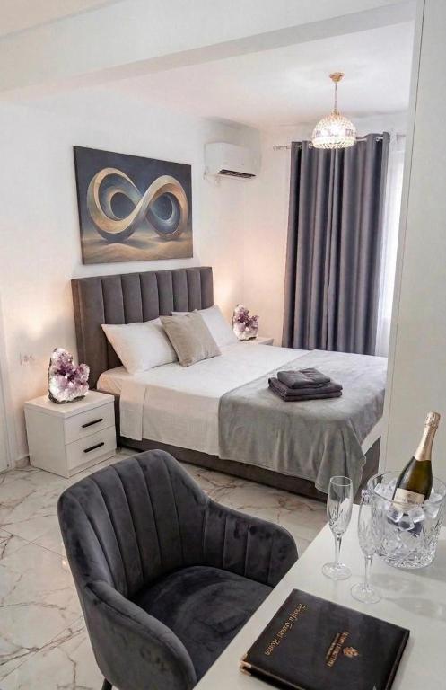 a bedroom with a bed and a chair and a table at Rozafa Guest Room Center in Shkodër