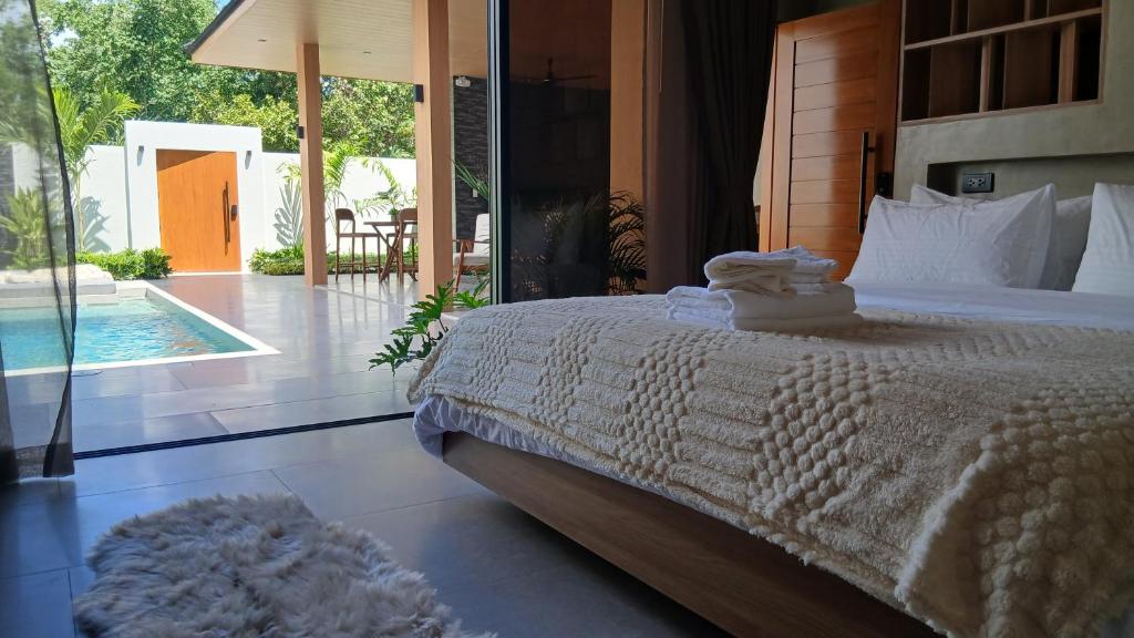 a bedroom with a bed and a view of a pool at Taluna Villas in Panglao Island